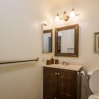 A small bathroom with a vanity, mirror, and lighting fixture.