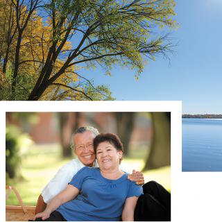An elderly couple seated together in a park, enjoying a sunny day surrounded by nature.
