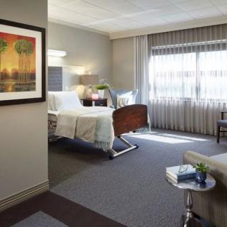 A clean and well-lit hospital room with a bed and medical equipment.