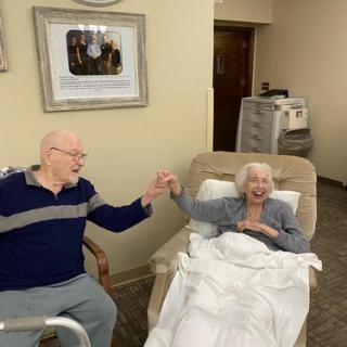 A loving moment shared between an elderly couple in a care facility.