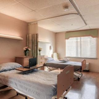 A clean and well-organized hospital room with two beds, showcasing a standard healthcare setting.
