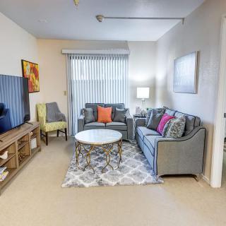 A cozy living room with modern decor, featuring a sofa, coffee table, and television.