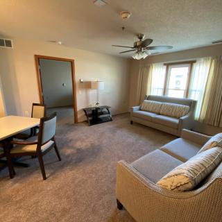 A cozy living room with a sofa, dining table, and large window.