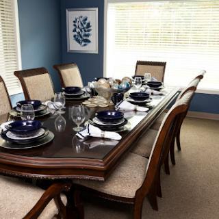 A beautifully set dining table in an elegantly decorated blue dining room, ready for a formal meal.