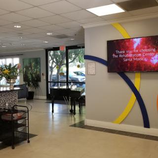 A modern waiting area featuring comfortable seating and a digital display.