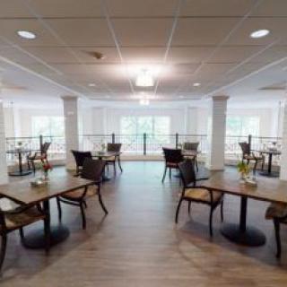 A spacious and modern dining area with neatly arranged tables and chairs.