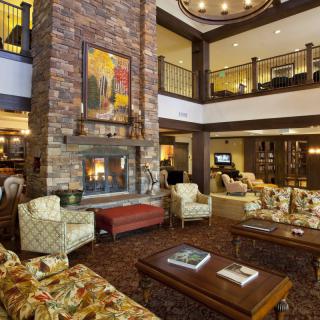 Elegant hotel lobby with comfortable seating and a central fireplace.