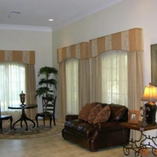 A cozy living room with a sofa, coffee table, and elegant curtains accompanied by decorative elements.