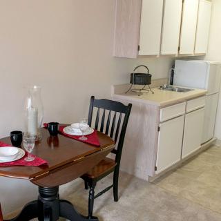 A compact kitchen area with a small dining table set for two.