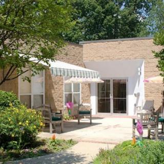 A small building entrance with outdoor seating and a garden area.