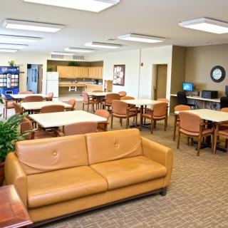 A spacious lounge area with tables, chairs, and a sofa.
