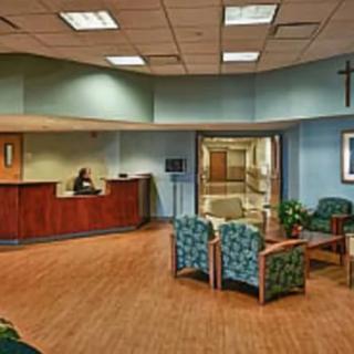 A hospital waiting room with a reception desk and seating area.