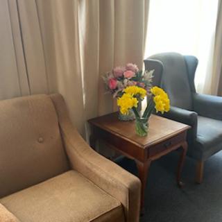 Cozy seating area with a vase of flowers on a side table.