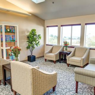 A cozy waiting room with comfortable chairs and large windows letting in natural light.