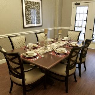 A beautifully set dining table with elegant chairs and place settings in a well-decorated room.