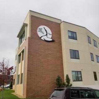 A close-up view of a multi-story building featuring a prominent logo sign on its exterior wall.