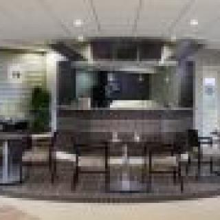 A modern reception area featuring a desk and several chairs.