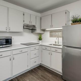 A modern kitchen with white cabinets and stainless steel appliances.