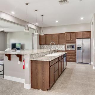 A modern kitchen with wooden cabinets, granite countertops, and stainless steel appliances.