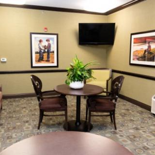 A waiting room with a small table, chairs, and decorative elements.