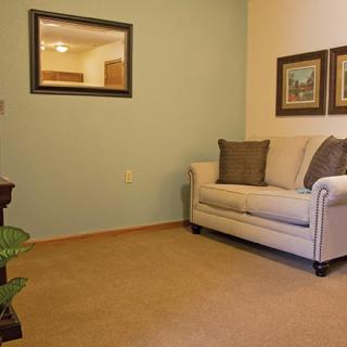 A cozy living room with a sofa, mirror, and artwork on the walls.
