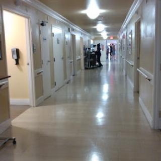 A view down a hospital hallway, lined with patient rooms.