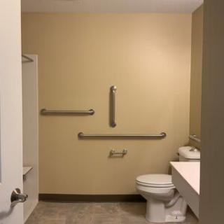 A handicap-accessible bathroom with grab bars and a toilet.