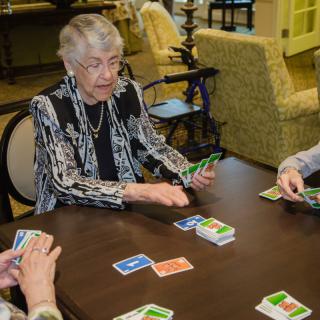 A group of seniors enjoying a card game together at a cozy indoor setting.