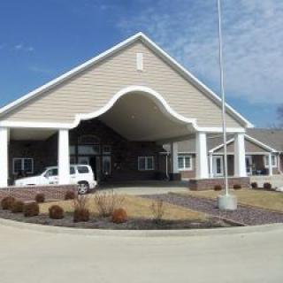 A building entrance with a covered driveway and columns.