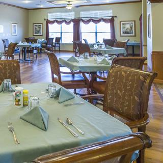 An elegant dining room with neatly set tables and chairs.