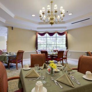 An elegantly set dining room with a chandelier and neatly arranged tables.