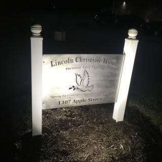 A illuminated sign at night displaying the name and details of a facility.