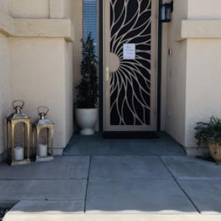 A stylish entrance featuring a decorative door and lanterns on the porch.