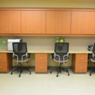 An organized office workspace with three chairs and desks.