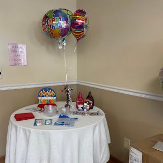 A festive table setup featuring colorful balloons and party supplies, perfect for a celebration.