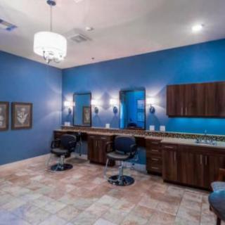 A modern salon interior with blue walls, styling chairs, and mirrors.