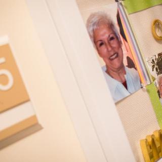 A hallway with a portrait photo on the wall and a door sign marked '5'.