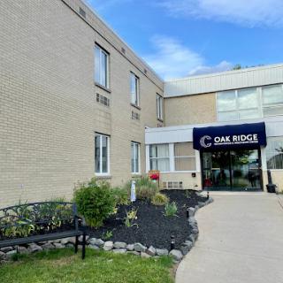 A view of a two-story building showcasing its entrance and landscaped area.