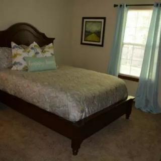 A cozy bedroom with a neatly made bed and soft lighting.