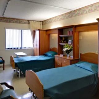 A hospital room with two beds and medical equipment.