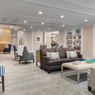 A modern living room with comfortable seating, bookshelves, and a coffee table.