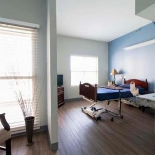 A clean and well-lit hospital room with two beds and medical equipment.