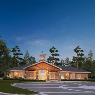 A beautifully designed community center at dusk, surrounded by trees and landscaped grounds.