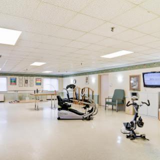 A spacious rehabilitation room equipped with exercise machines and therapy facilities.