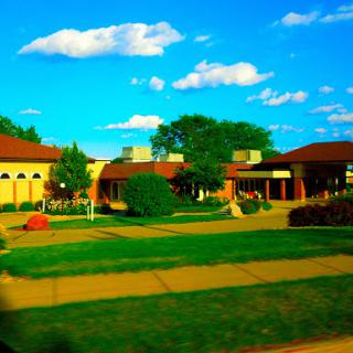 A vibrant view of a community building surrounded by greenery and blue skies.