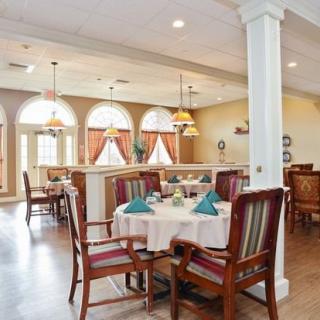 A well-lit dining area with elegantly set tables and comfortable seating.