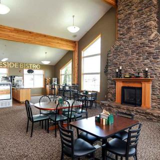 A cozy dining area with a stone fireplace and wooden furniture.