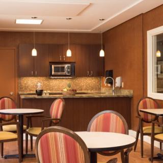 A modern kitchen and dining area with tables, chairs, and a microwave.