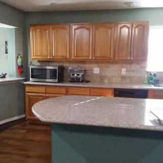 Modern kitchen with wooden cabinets and a granite countertop.