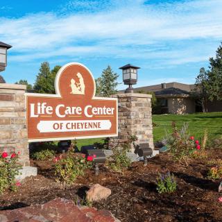 Entrance sign for Life Care Center of Cheyenne, surrounded by landscaped gardens.
